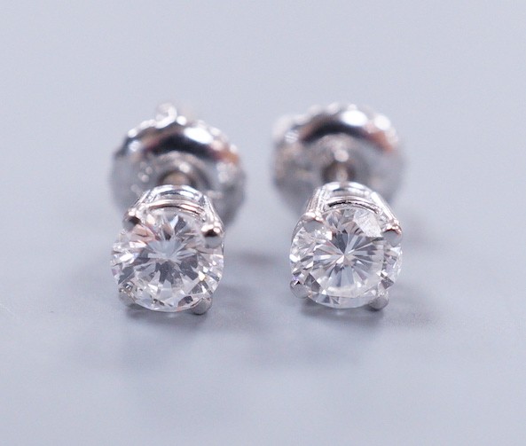 A pair of 18k white metal and solitaire diamond set ear studs, gross weight 0.9 grams